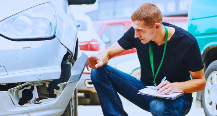 Insurance staff evaluating the damage of a car after an accident.